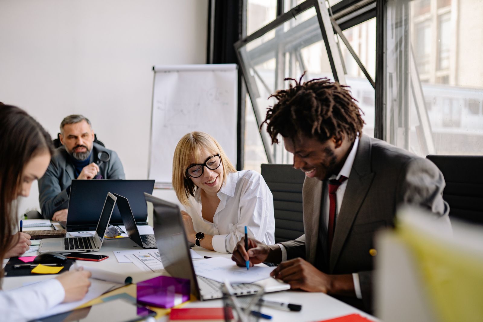 Professionals sharing ideas around a table in a bright office